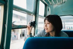 ボンネットバスでカメラを向ける女性の写真