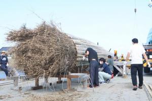 大たいまつの土台に手作業で割った竹を張り付ける