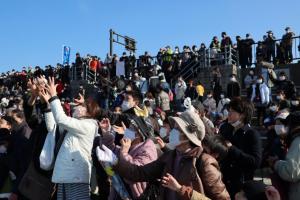 宝来船から撒かれる紅白餅を拾う観客