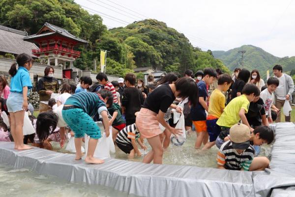 魚のつかみ取りをする子供たちの写真