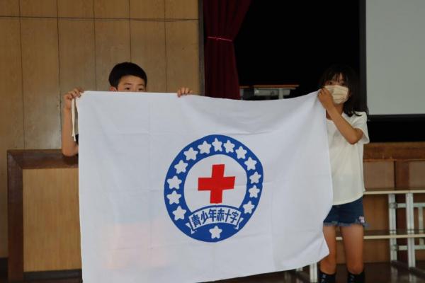 青少年赤十字の旗をもつ児童代表の二人