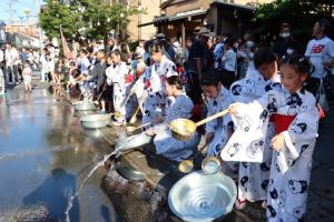 打ち水をする浴衣姿の子どもたち