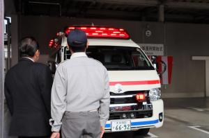 救急車両の外装や赤色警光灯を見る佐々木市長の写真