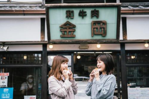 昭和の町で食べ歩きをしている写真