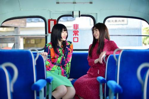 ボンネットバスの車内で話す二人の女性の写真