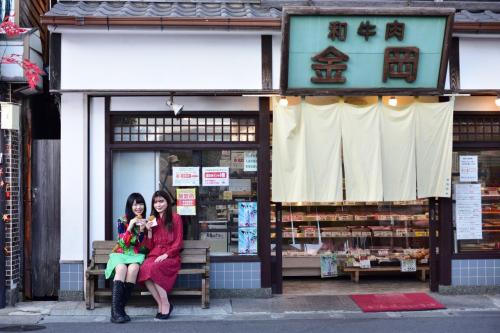 昭和の町商店街で食べ歩きをする女性二人の写真