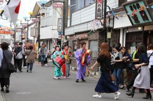 昭和の町商店街をチンドンが練り歩く写真