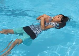 ペットボトルをもって浮く練習をする子どもの写真
