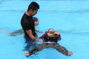 ランドセルを使って浮く練習をする子どもと講師の写真