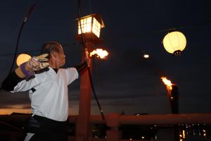橋の上から火矢を射る様子の写真