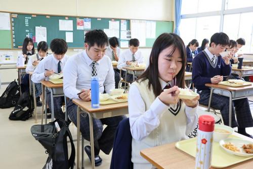 昼食を食べている高田高校生たちの写真