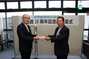 土谷社長が佐々木市長に目録を手渡している写真