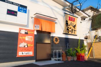 商店街の大通り沿いにあります。オレンジの暖簾と大きなお店の看板が目印です。の画像
