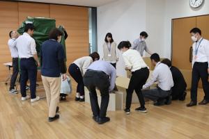 簡易テント、ベッドを組み立てている職員の写真
