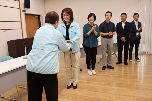 キャップを手渡す大波多会長と受け取る谷口さんの写真