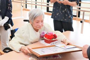 受け取った報賞状を見つめる江口さん