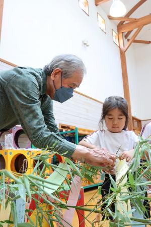 老人クラブの方と園児が一緒にかざりつけている写真