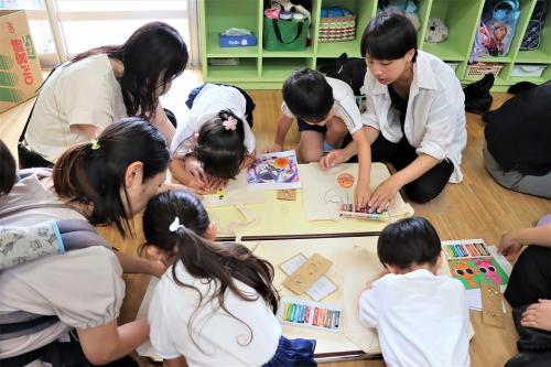 マイバッグづくりを楽しんでいる園児と保護者の写真