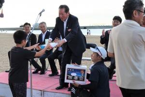 賞品を渡している佐々木市長と受け取る当選者の写真