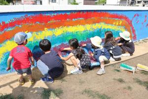 壁に手形をつけている子どもたちの写真