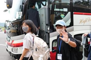 見送りに手を振っている児童の写真