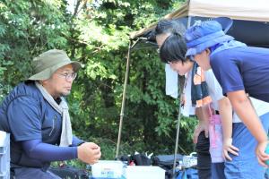 玉川准教授から出土品の説明を聞く参加者