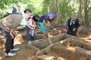 玉川准教授から石棺の説明を聞く参加者