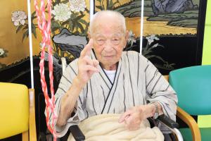 元気なピースサインを向ける井口さんの写真