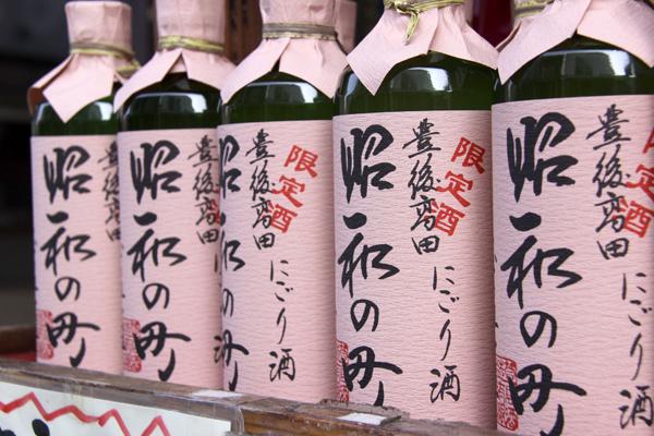 一店一品の『昔ながらのどぶろく風にごり酒』です。地元の材料を使った地元のお酒で、「西の関」というお酒で有名な「萱島酒造」で作られているそうです。どぶろく祭りの時に使われるお酒とは違い熱を通しているので、大変飲みやすいとの事です。「昭和の町のにごり酒（500ml）」1本700円。箱入りは1本800円にて販売中です。の画像