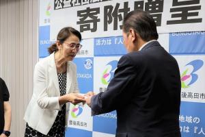 目録を手渡す石田部会長と受け取る佐々木市長の写真