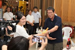 西都市長から参加者へ地酒のプレゼントの様子