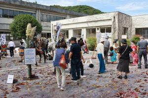 案山子展示と展示を見ている来場者たちの写真