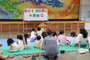 絵本を見ているたくさんの子どもたちの後ろ姿