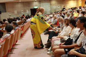 プレゼントを受け取る来場者と渡している劇団員の写真
