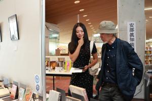 装画本をみているまのうさんとかわじさんの写真