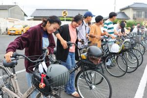 参加者たちが自転車のブレーキをチェックしている様子の写真