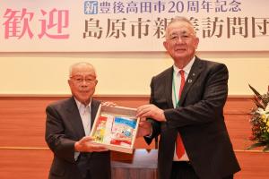 島原市からのお土産を掲げるお二人