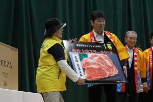 当選者に景品パネルを手渡している写真