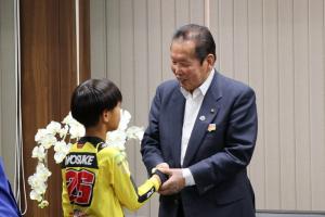 渡邉くんの手を握ってお祝いの言葉をかけている市長の写真