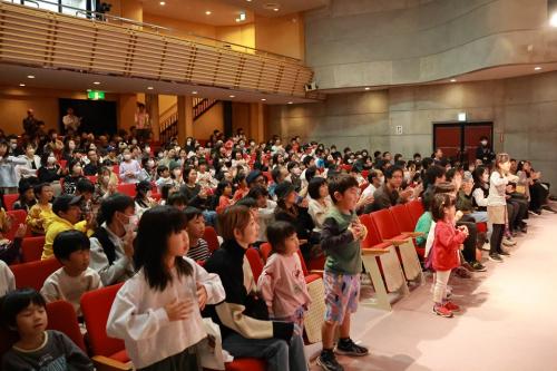 踊りを踊っている子どもたちを含む来場者たちの写真