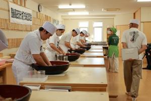 試験中の受験者たちと審査員たちの写真