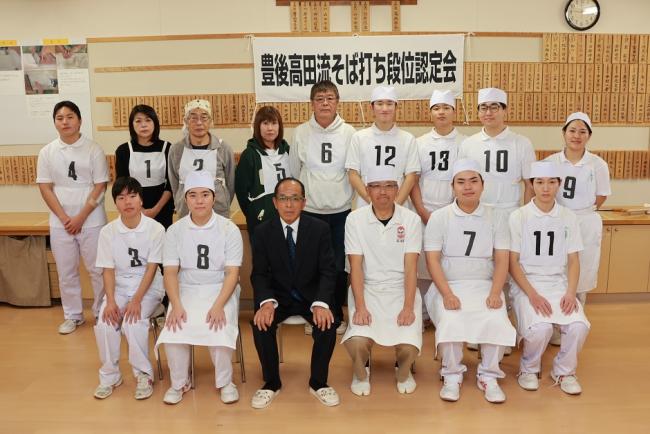 受験者と末宗代表、山本師範代が写った記念写真