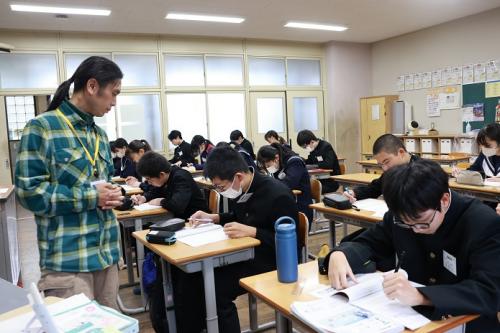 問題を解いている生徒たちとその様子を見ている講師の写真