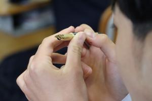 寄贈された万年筆のペン先を確認する生徒