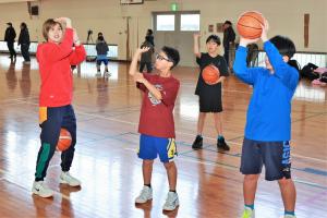 川原さんにシュートの仕方を教えてもらう児童たち