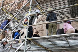 足場の上から摩崖仏を見学する参加者