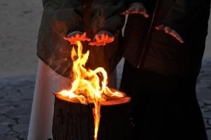 スウェーデントーチの火に手をかざす参加者