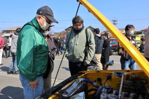 展示されたレトロカーをじっくり眺める来場者の写真