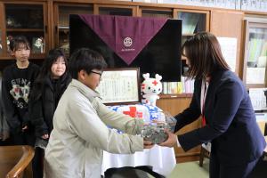 児童代表から沖本さんに募金が手渡される写真