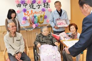 褒賞状を読み上げる市長を見つめる田中さん